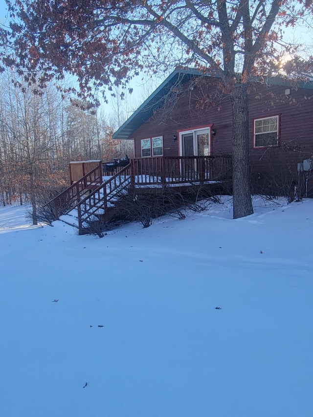 snow covered house with a wooden deck