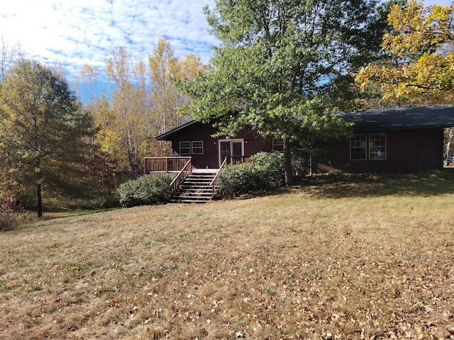 exterior space with a deck, a front lawn, and stairs