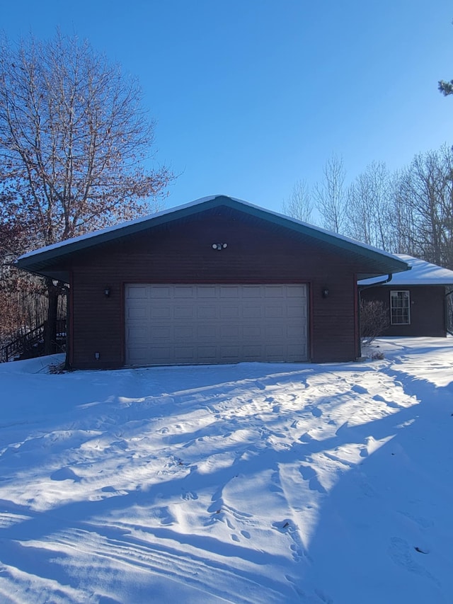 snow covered garage with a garage