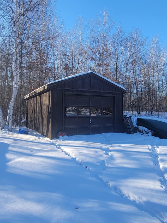 snow covered garage featuring a detached garage