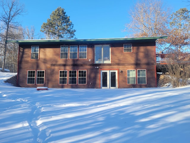 view of snow covered back of property