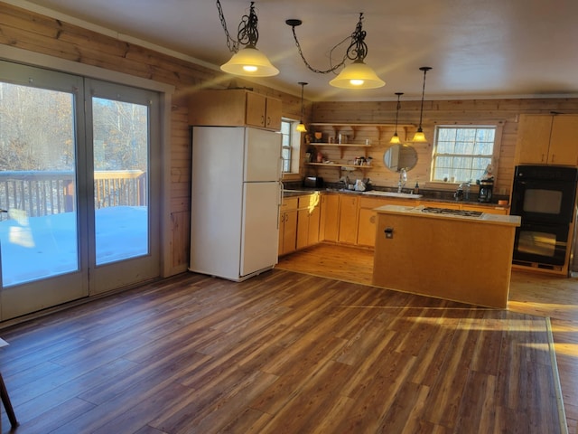 kitchen featuring open shelves, dark wood-type flooring, freestanding refrigerator, and stainless steel gas stovetop