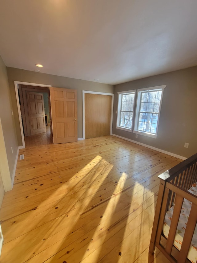 unfurnished bedroom with recessed lighting, visible vents, baseboards, light wood-style floors, and a closet