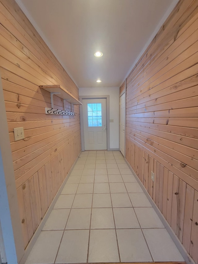 doorway with recessed lighting, wooden walls, and light tile patterned floors