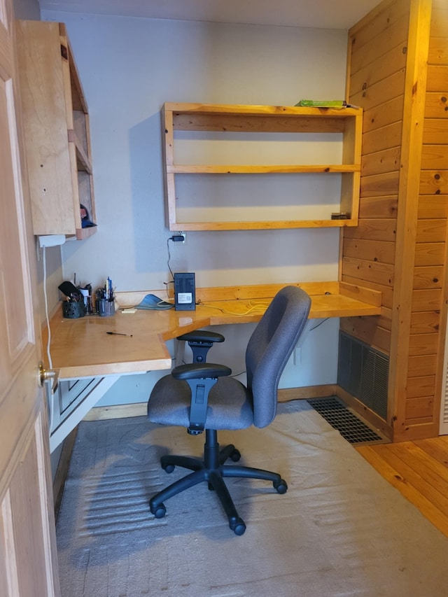 home office with built in desk and wood finished floors