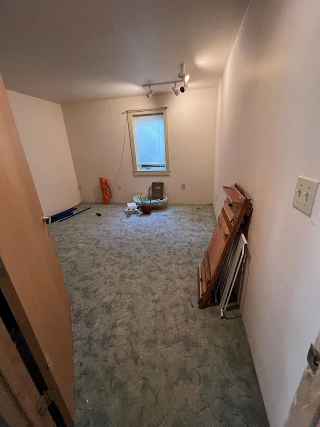 spare room featuring carpet floors and track lighting