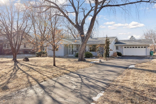 ranch-style house featuring a garage and driveway