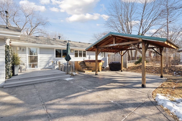 view of patio / terrace featuring a carport, concrete driveway, and a wooden deck