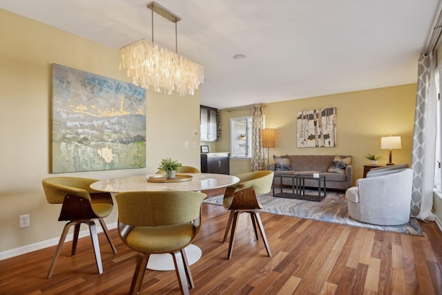 dining room with an inviting chandelier, baseboards, and wood finished floors