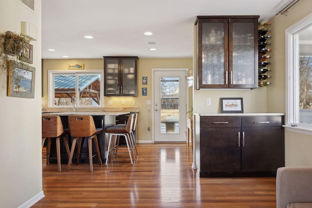 bar with recessed lighting, wood finished floors, and baseboards