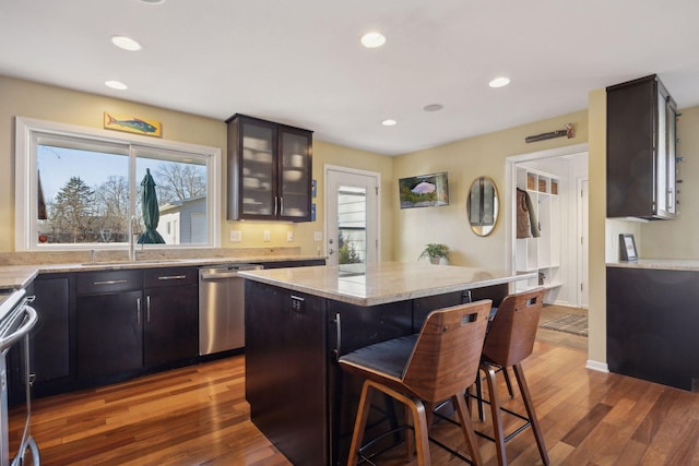 kitchen featuring plenty of natural light, a breakfast bar area, stainless steel appliances, and a sink