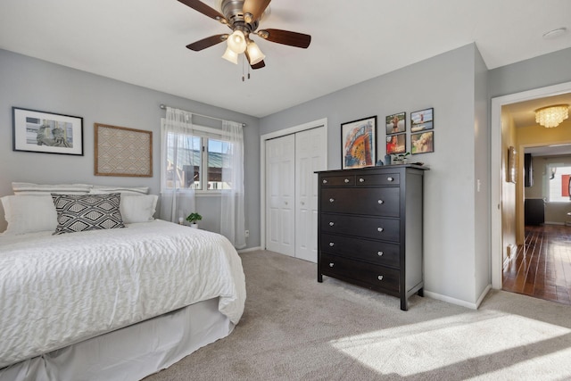 bedroom with light colored carpet, a closet, multiple windows, and baseboards