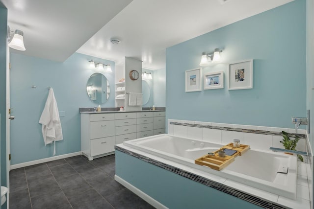 bathroom with baseboards, vanity, a bath, and tile patterned floors