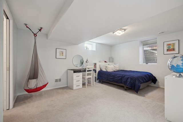 carpeted bedroom with visible vents, multiple windows, and baseboards