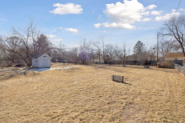 view of yard with fence, a storage unit, and an outdoor structure