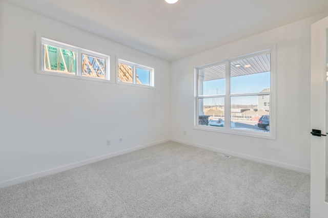 unfurnished room featuring carpet and baseboards