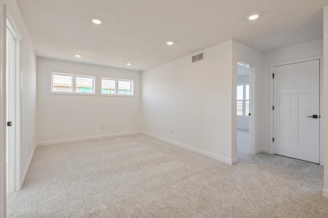 unfurnished room featuring recessed lighting, visible vents, baseboards, and light colored carpet