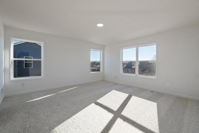 unfurnished room with carpet and baseboards