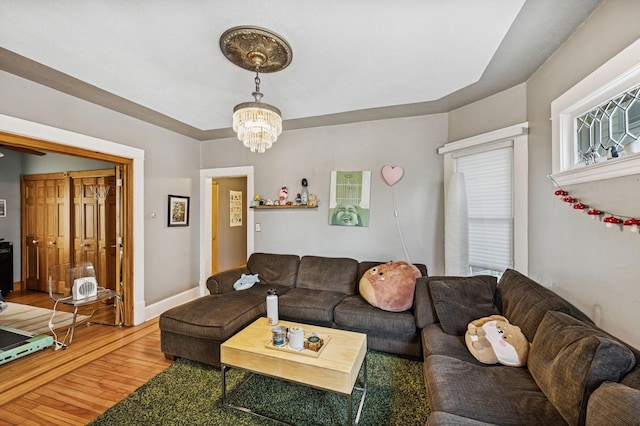 living area with a notable chandelier, wood finished floors, and baseboards