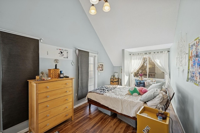 bedroom featuring lofted ceiling, baseboards, and wood finished floors