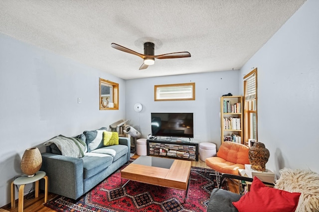 living room featuring a textured ceiling, a ceiling fan, and wood finished floors