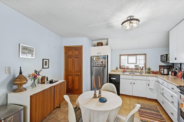 kitchen with light tile patterned floors, light countertops, appliances with stainless steel finishes, and a sink