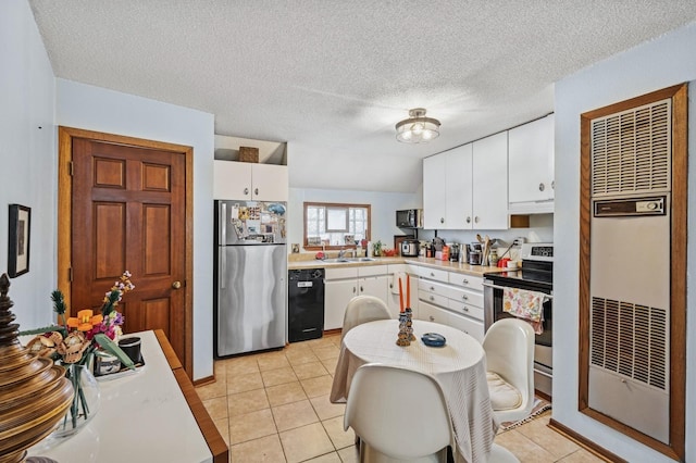 kitchen featuring light tile patterned floors, stainless steel appliances, light countertops, and white cabinetry