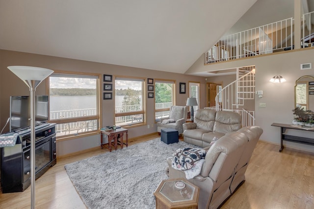 living room with baseboards, visible vents, stairway, wood finished floors, and high vaulted ceiling