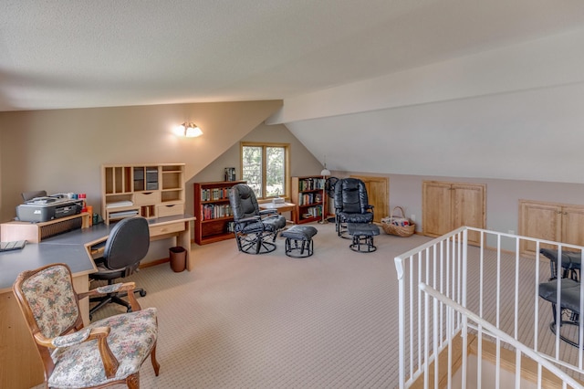 office area featuring carpet floors, vaulted ceiling, and a textured ceiling