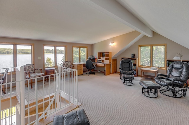 home office with plenty of natural light, lofted ceiling with beams, a water view, and light colored carpet