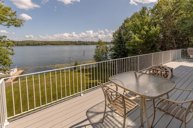 deck with a water view and a lawn