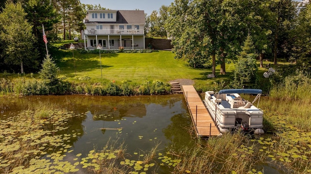 view of dock with a water view and a lawn