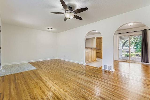 11570 Juniper St NW, Coon Rapids, MN 55448 - empty room featuring arched walkways, light wood-style floors, and a ceiling fan