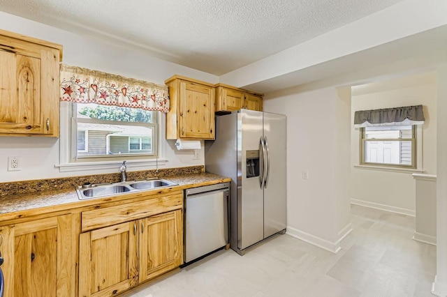 11570 Juniper St NW, Coon Rapids, MN 55448 - kitchen with stainless steel dishwasher, dark countertops, plenty of natural light, a textured ceiling, and light flooring