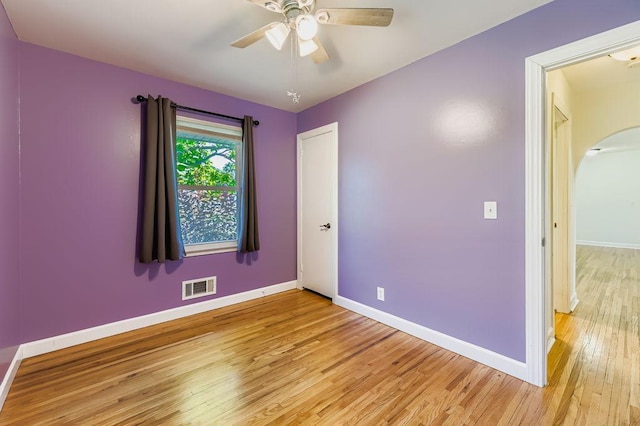 11570 Juniper St NW, Coon Rapids, MN 55448 - spare room featuring light wood-style floors, arched walkways, and ceiling fan