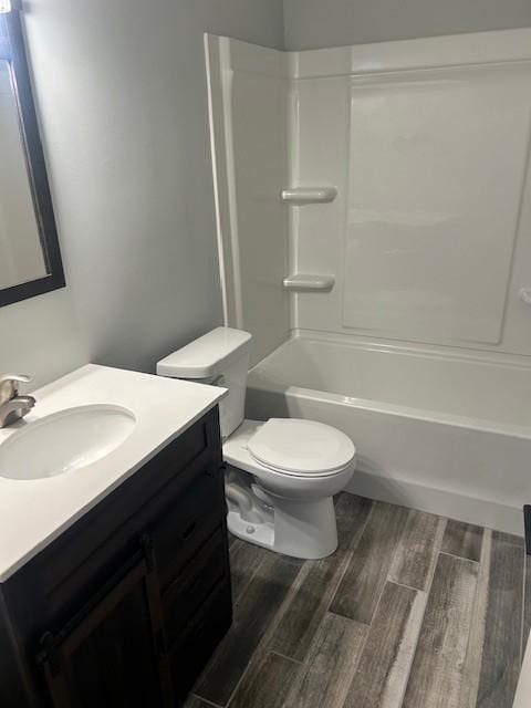 full bath with shower / washtub combination, toilet, vanity, and wood finished floors