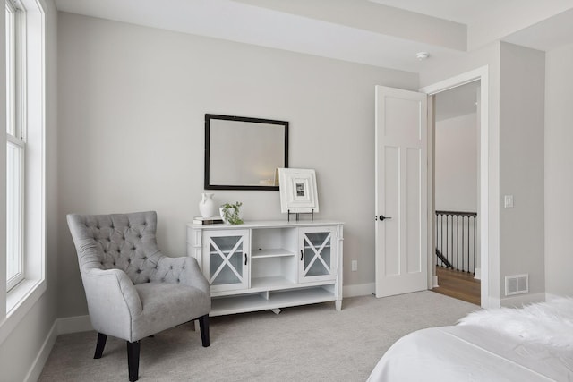 bedroom with baseboards, visible vents, and light colored carpet