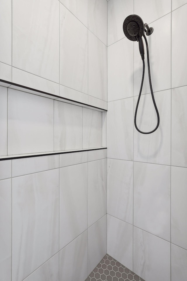 interior details featuring tiled shower