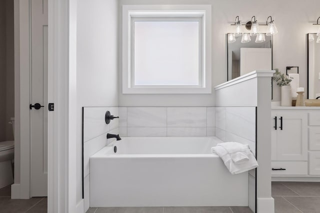 bathroom with toilet, tile patterned flooring, a bathtub, and vanity