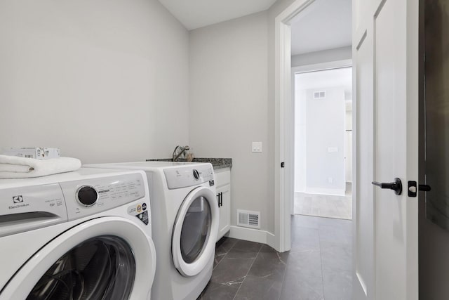 laundry area with visible vents, cabinet space, washer and clothes dryer, and baseboards