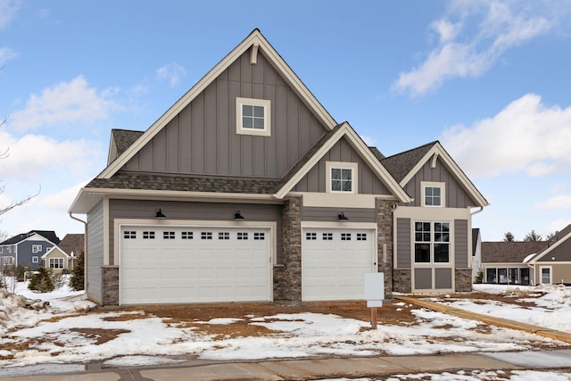 craftsman house with roof with shingles, stone siding, board and batten siding, and an attached garage