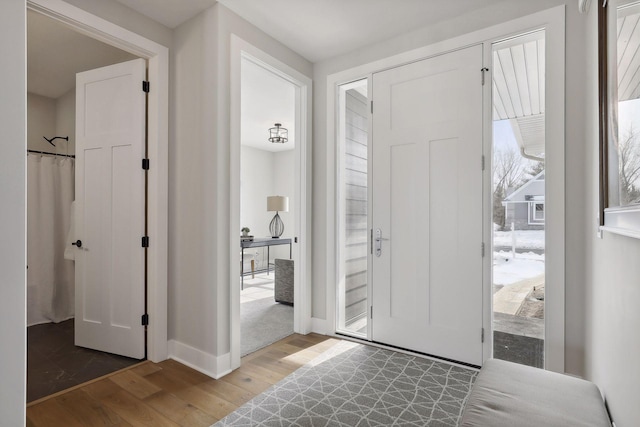 foyer with baseboards and wood finished floors