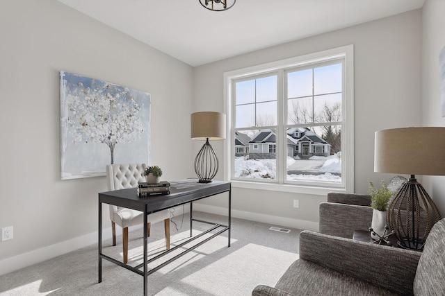 office featuring baseboards, visible vents, and light colored carpet