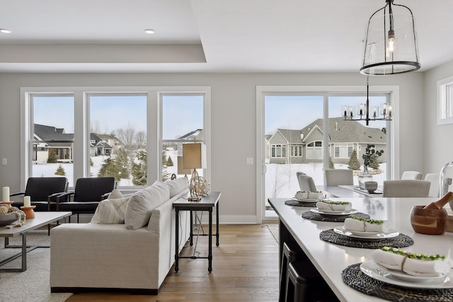 interior space with a residential view, a notable chandelier, baseboards, and wood finished floors