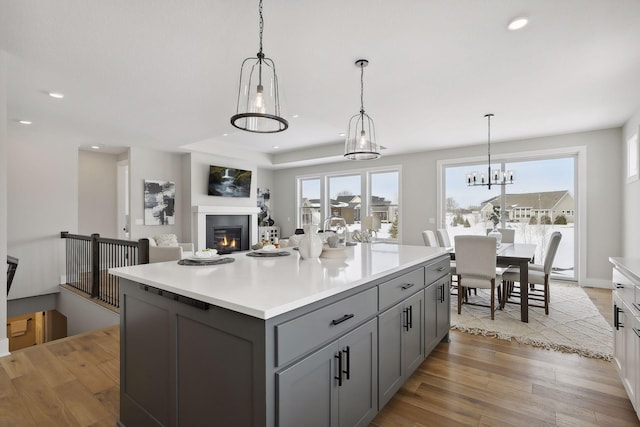 kitchen featuring light countertops, hanging light fixtures, gray cabinets, and light wood-style flooring