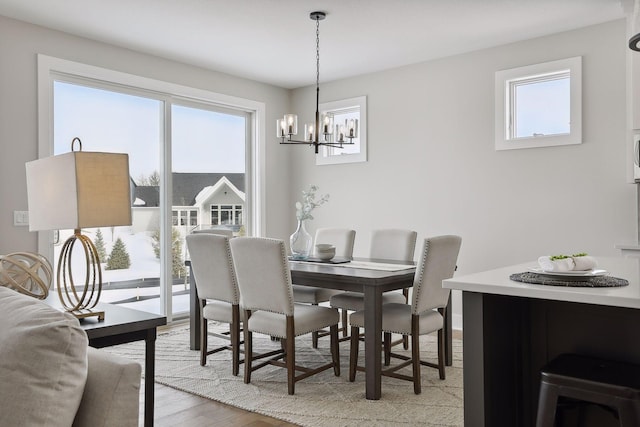 dining room with a chandelier, light wood finished floors, and a healthy amount of sunlight