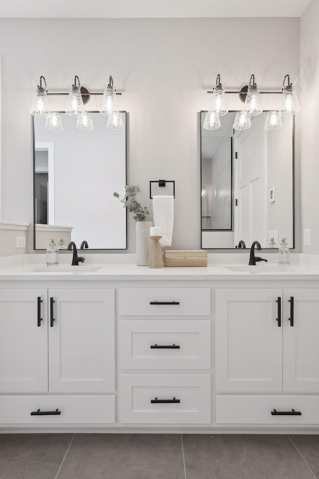 full bath with double vanity, a sink, and tile patterned floors