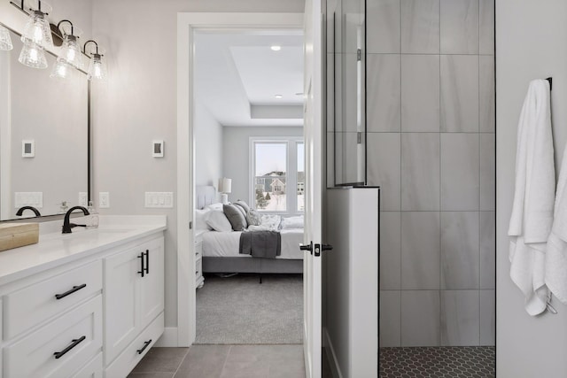 ensuite bathroom featuring ensuite bathroom, tiled shower, tile patterned flooring, and vanity