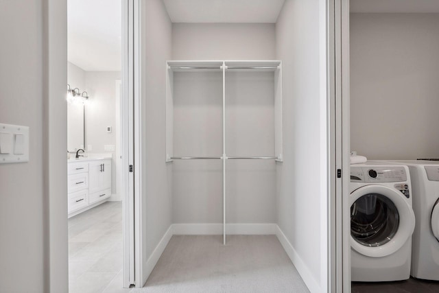 laundry area with light carpet, laundry area, baseboards, washer and dryer, and a sink