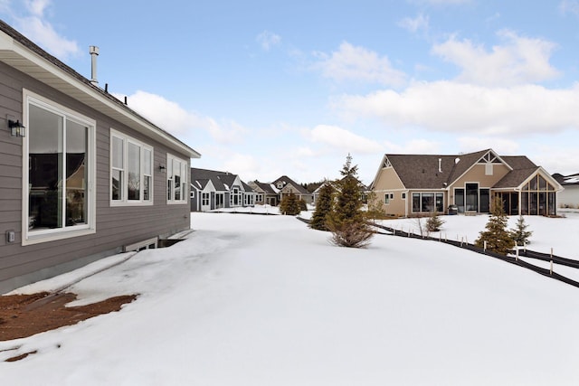 yard covered in snow with a residential view